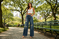 Model wearing ripped wide leg jeans in blue denim